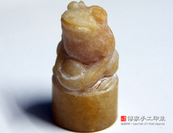 將水擦乾，看實際青蛙的細節有沒有做好。如果沒有做好，則繼續針對不足去修改和補強。如型態和細節都OK，則會開始進行拋光。下面這張青蛙的雕刻，可以看出青蛙的眼睛、嘴巴、身形、手腳、都很清楚，但是抱著金元寶的樣貌還不是很清楚，則師父需要針對這一部分，再去琢磨-圖片