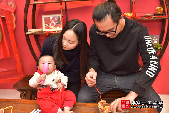 台中市北區張寶寶古禮收涎祝福活動:為寶寶戴上收涎餅乾。照片1