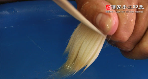 用牛骨的刷子去除羊毛的頂部雜毛，只保留毛筆所需的材料實際圖