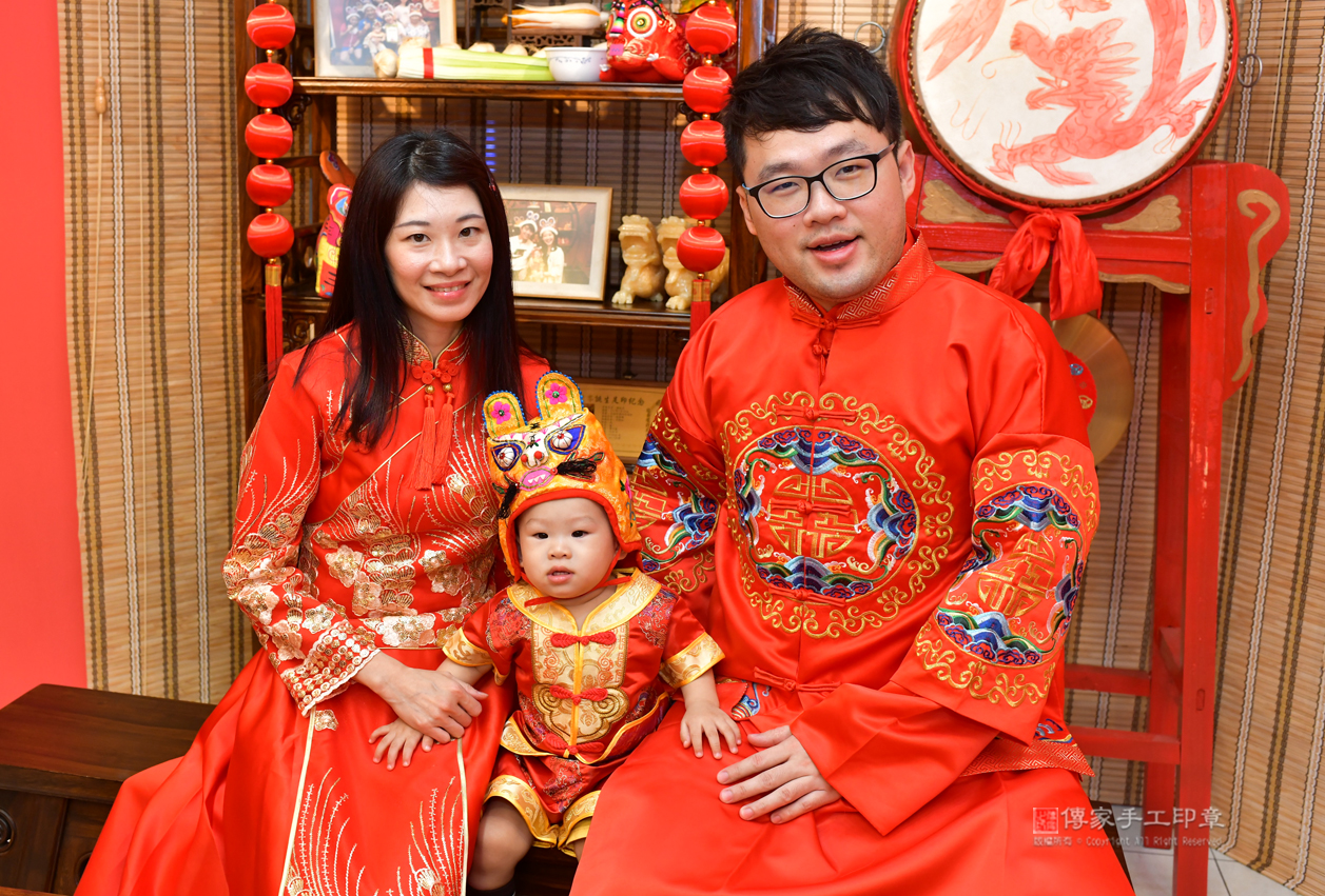 爸媽和小孩穿中國風的禮服，進行嬰兒古禮滿月剃頭照
