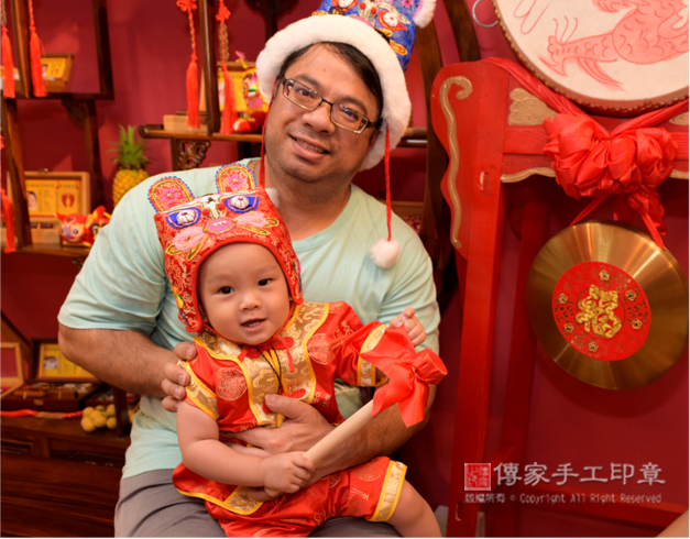 敲鑼儀式。爸爸抱著孩子拍合照1