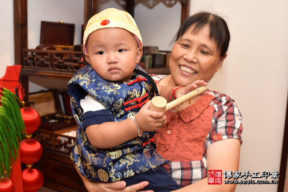 台中市北區洪寶寶實際週歲抓周，拿到的三個抓周物品包含：「木槌、算盤、滑鼠」。台中抓周照片1