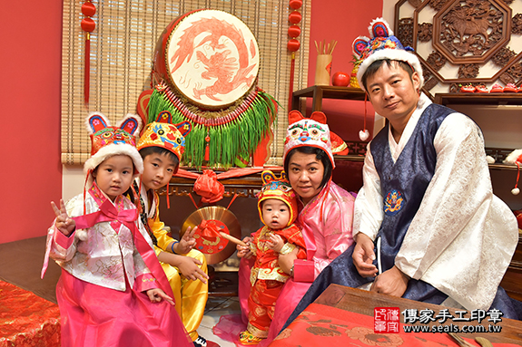 抓周儀式【敲鑼歌】朗誦祝福：增添喜氣，打響名號。 敲鑼歌是搭配朗誦和敲鑼的動作，讓孩子得到祝福。照片1