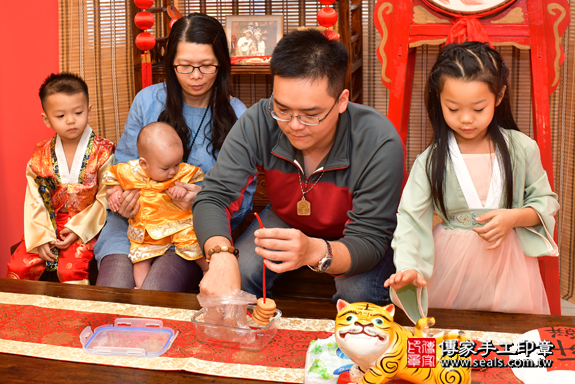 高雄市鳳山區陳寶寶古禮收涎祝福活動:為寶寶戴上收涎餅乾。照片3