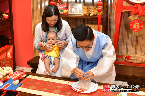 高雄市鳳山區李寶寶古禮收涎祝福活動:為寶寶戴上收涎餅乾。照片1