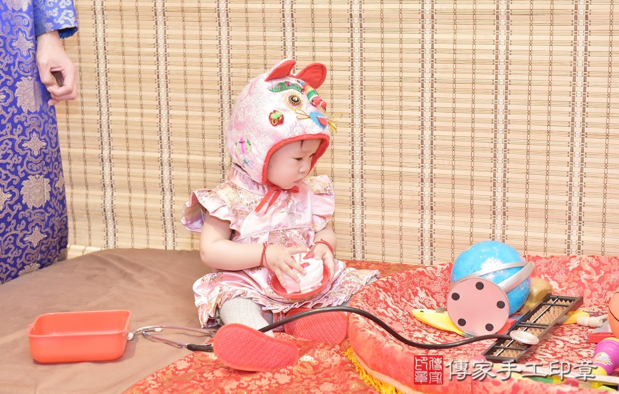 香山區謝寶寶實際週歲抓周，拿到的三個抓周物品包含：「蛋糕、球、算盤」。
