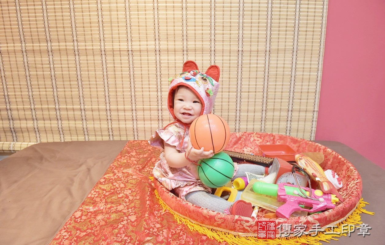 香山區謝寶寶實際週歲抓周，拿到的三個抓周物品包含：「蛋糕、球、算盤」。