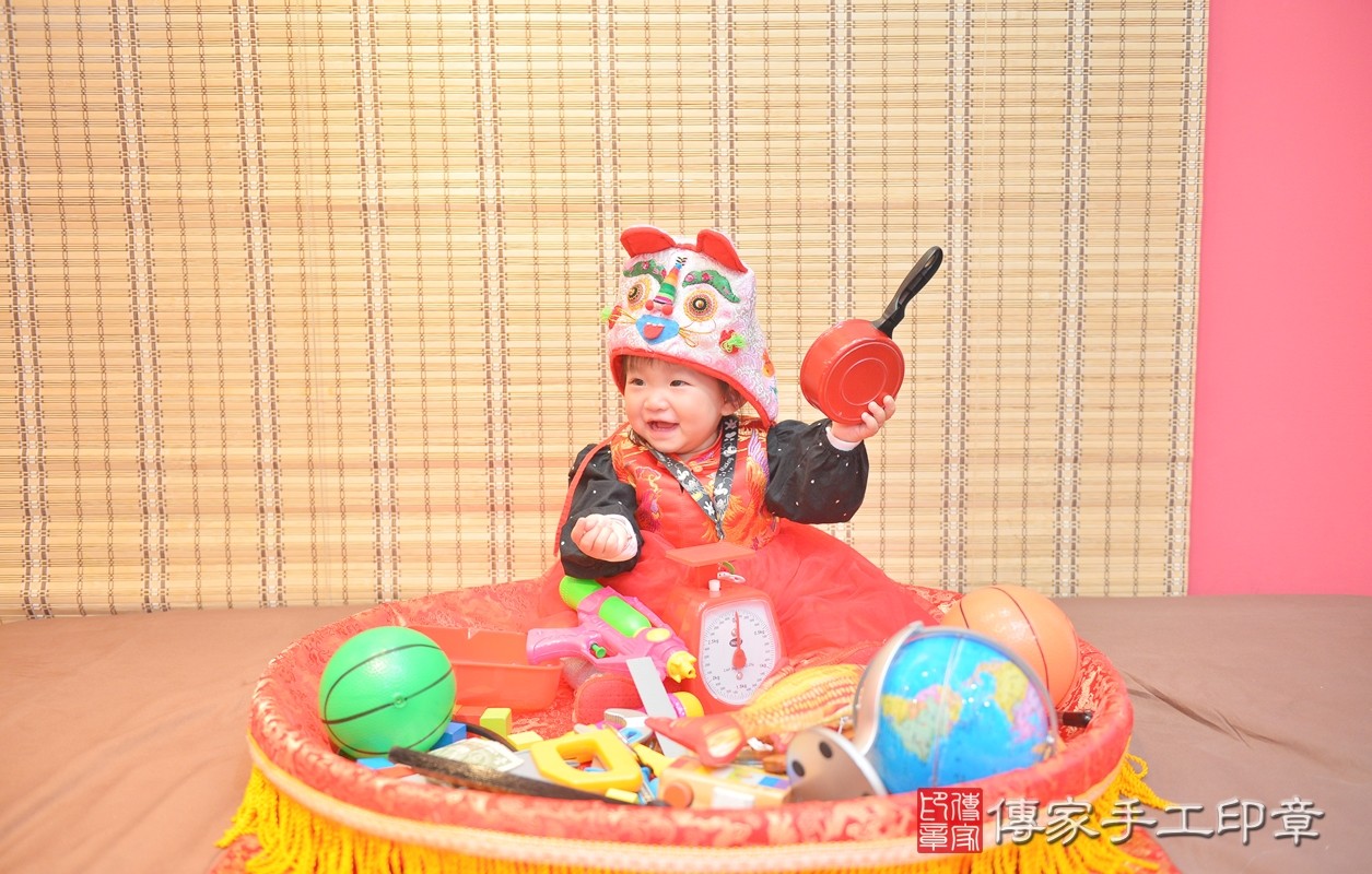 香山區曾寶寶實際週歲抓周，拿到的三個抓周物品包含：「手槍、秤子、鍋子」。